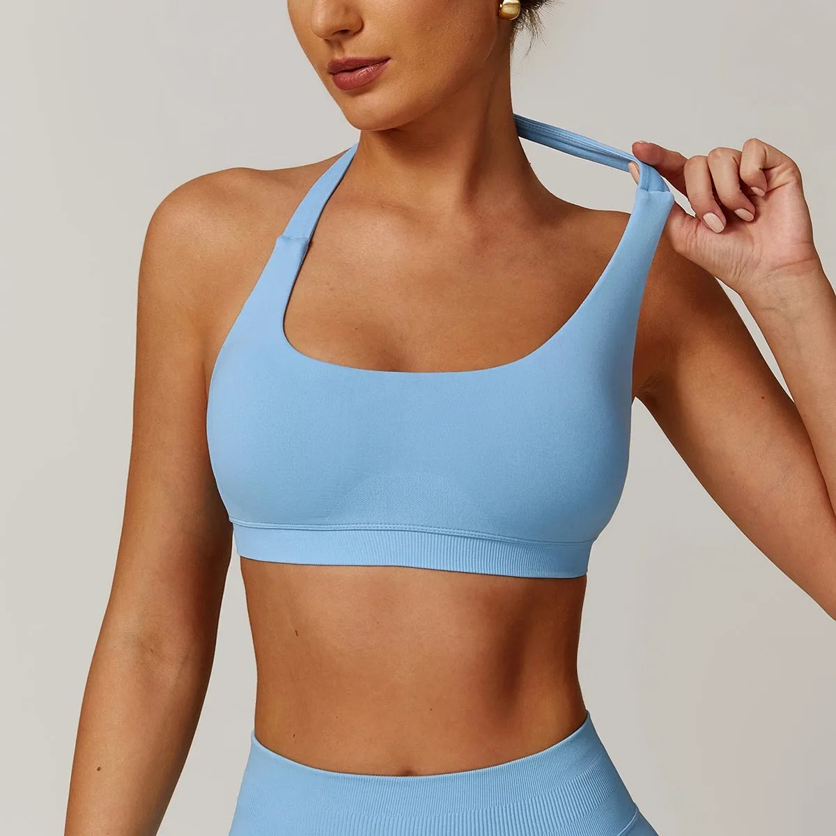 Women's black halter-style sports bra with removable pads for yoga and workout.
