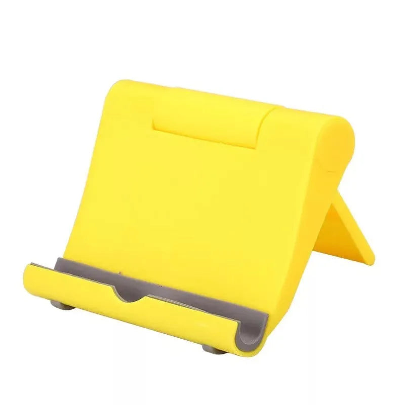 Black PE folding stand holding a smartphone at an angle on a wooden table.