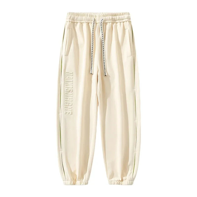 Men's loose fit cotton pants with elasticated ankle bands in grey green colour, showing collage stitching detail.