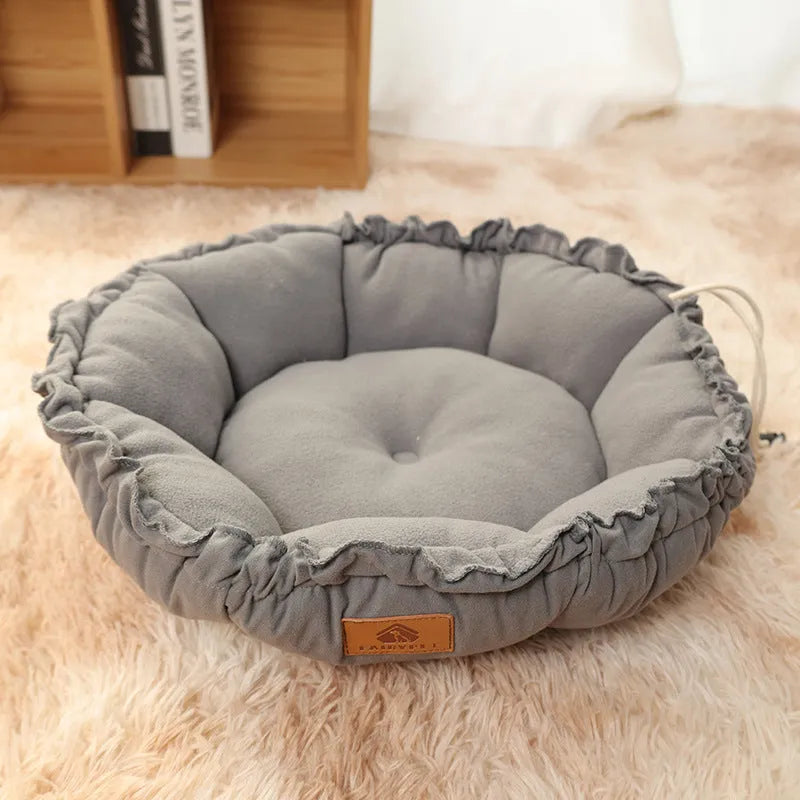 Grey and green reversible donut-shaped pet bed for cats and small dogs on a wooden floor.
