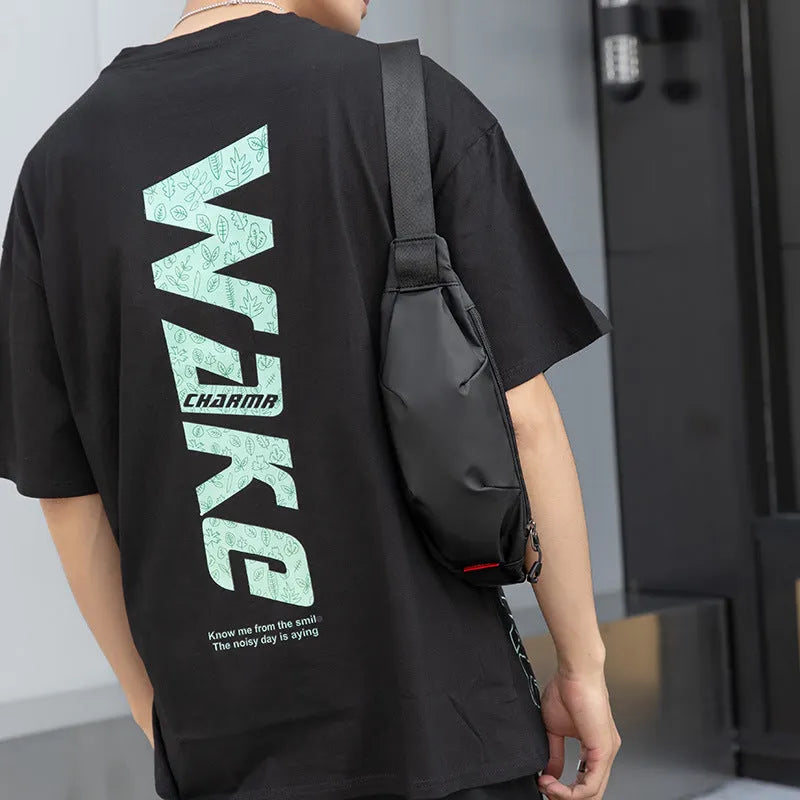 Men's black Oxford cloth crossbody waist pack showing front zipper and compact dimensions