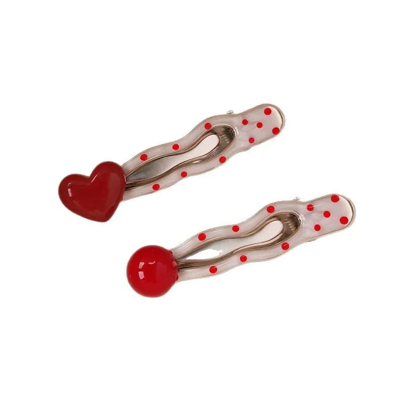 Red love heart-shaped plastic hair clip with retro dots and a willow leaf silhouette on a white background.