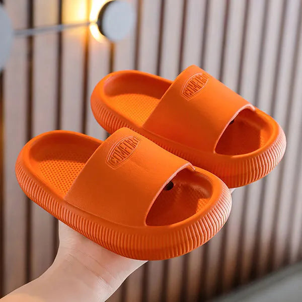 Colourful children's EVA slippers with a textured non-slip sole, shown in blue, green, orange, pink and yellow.