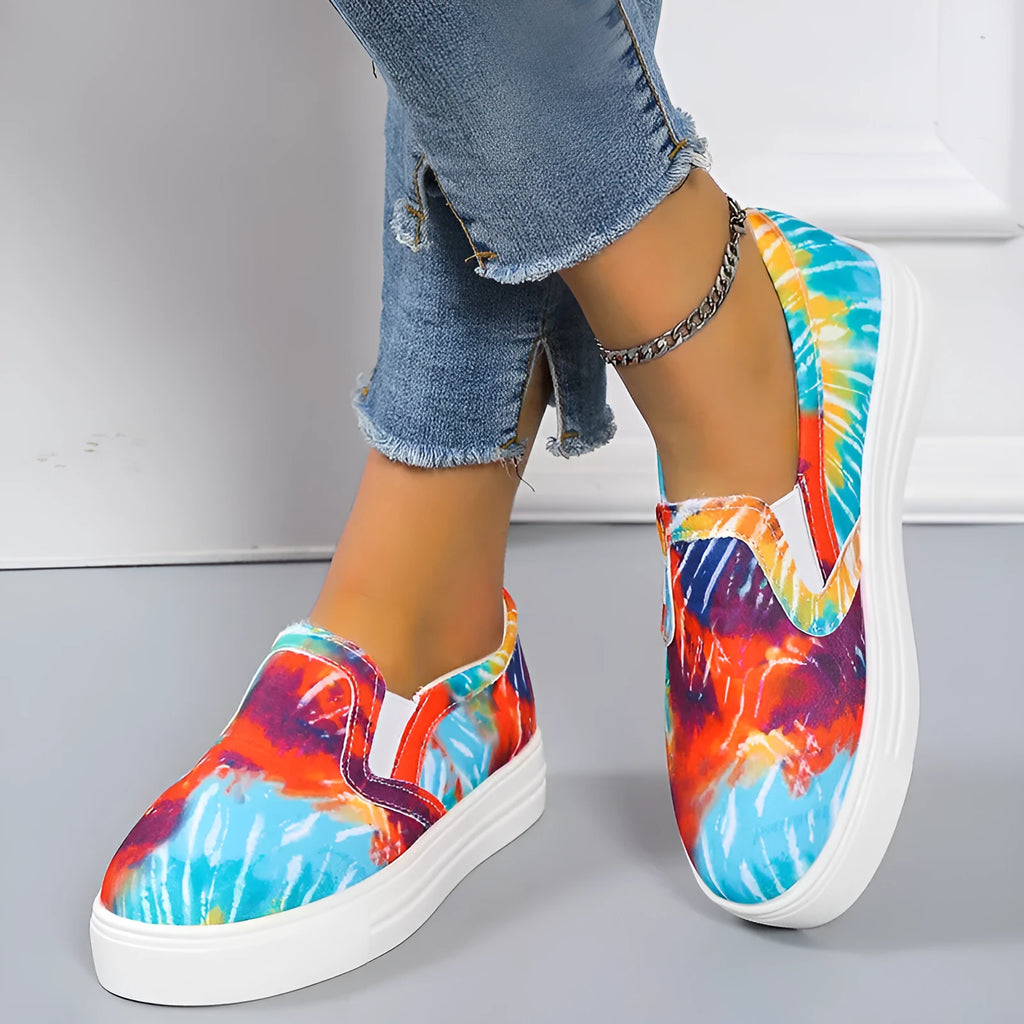 Women's low-top canvas trainers in blue, green, black and colourful designs on a flat rubber sole.