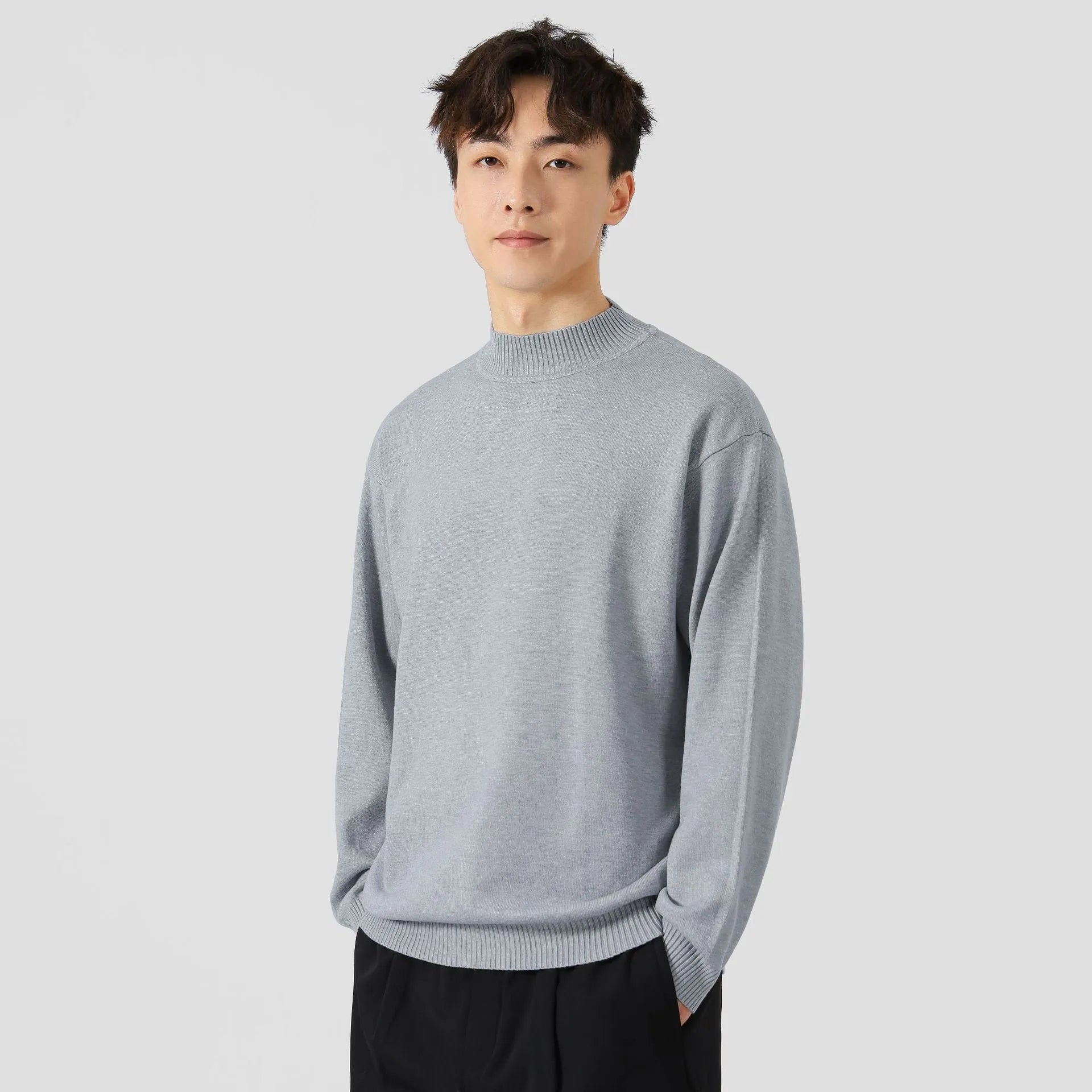 A man's loose-fitting, long-sleeve pullover sweater in a solid colour, showing a casual relaxed fit.