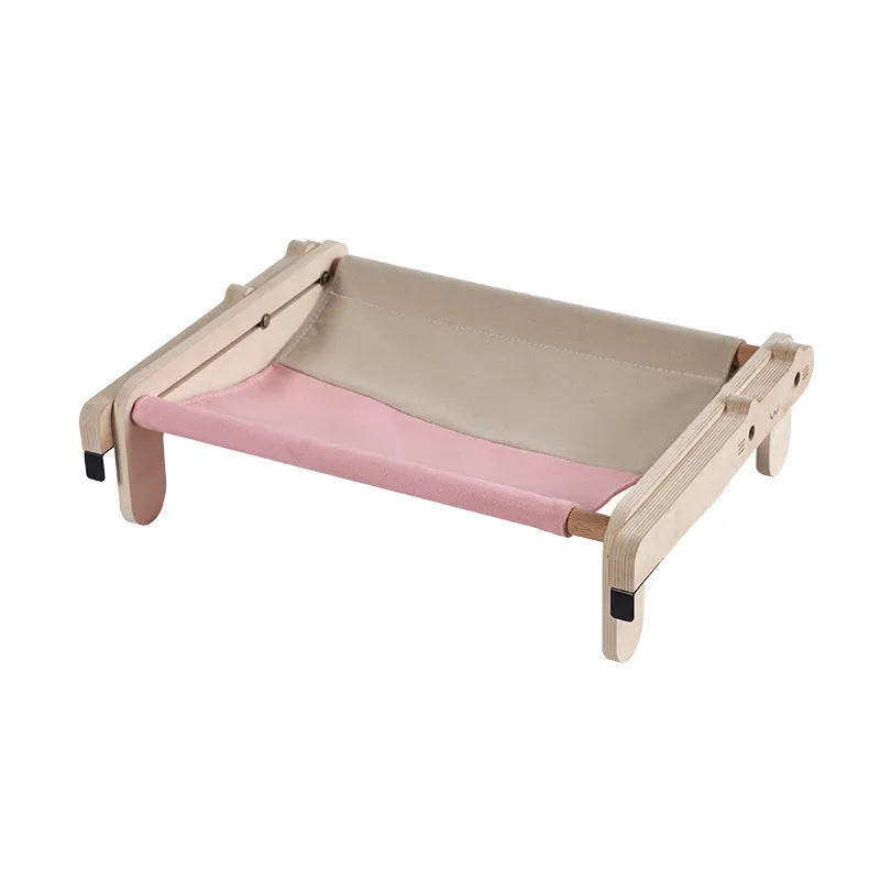 Solid wood cat bed with a removable plaid cushion on a wooden frame.