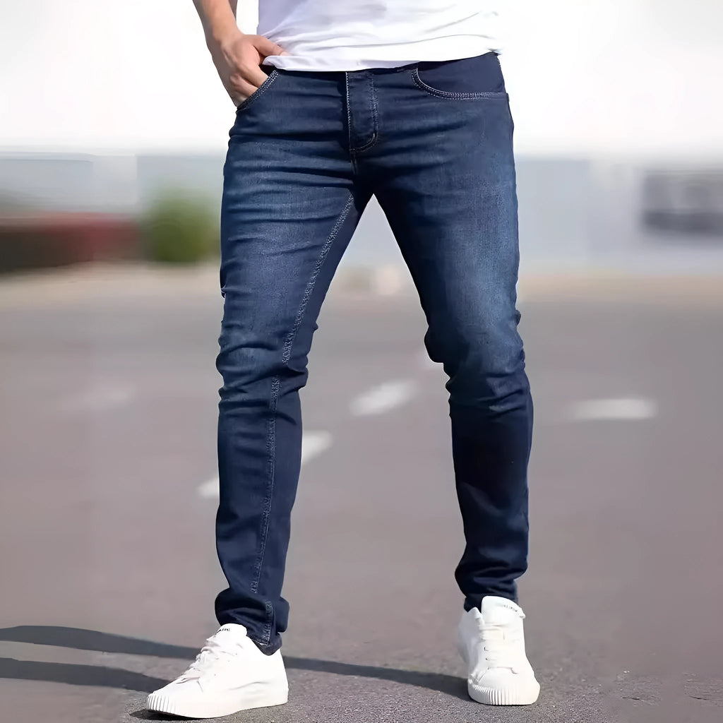 A man wearing dark blue slim fit casual jeans with an elastic waistband.