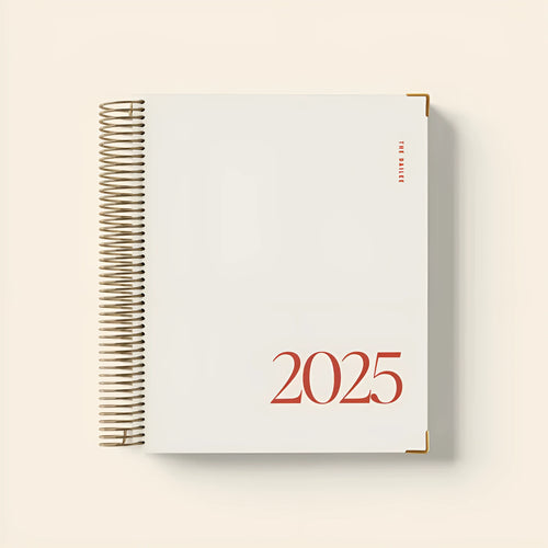 Cherry red A4 coil notebook open showing daily schedule layout with spiral binding
