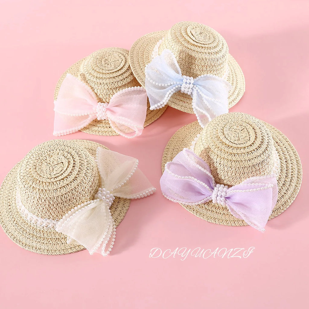 Woven straw cat hat with a pearl bow, shown in blue, pink, purple, and white colour options