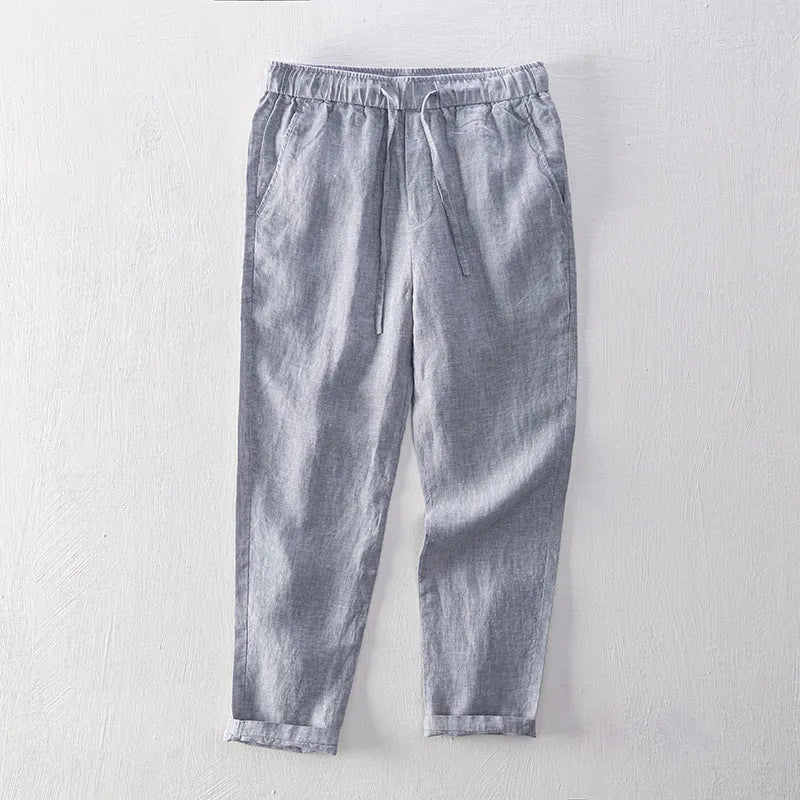 Men's straight-leg linen trousers in light gray shown laid flat.