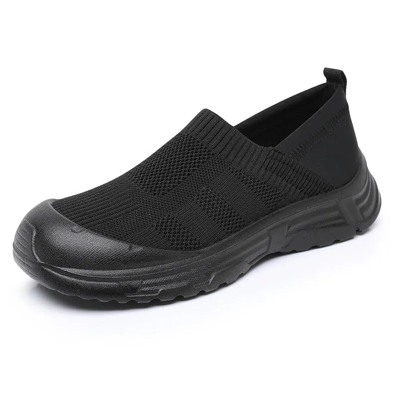 Women's black slip-on shoes with cloth upper and PVC sole showing one pedal design
