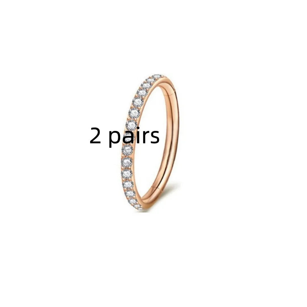 Close-up of a round, seamless stainless steel nose ring in a gold finish, showing its smooth, clasp-free design.