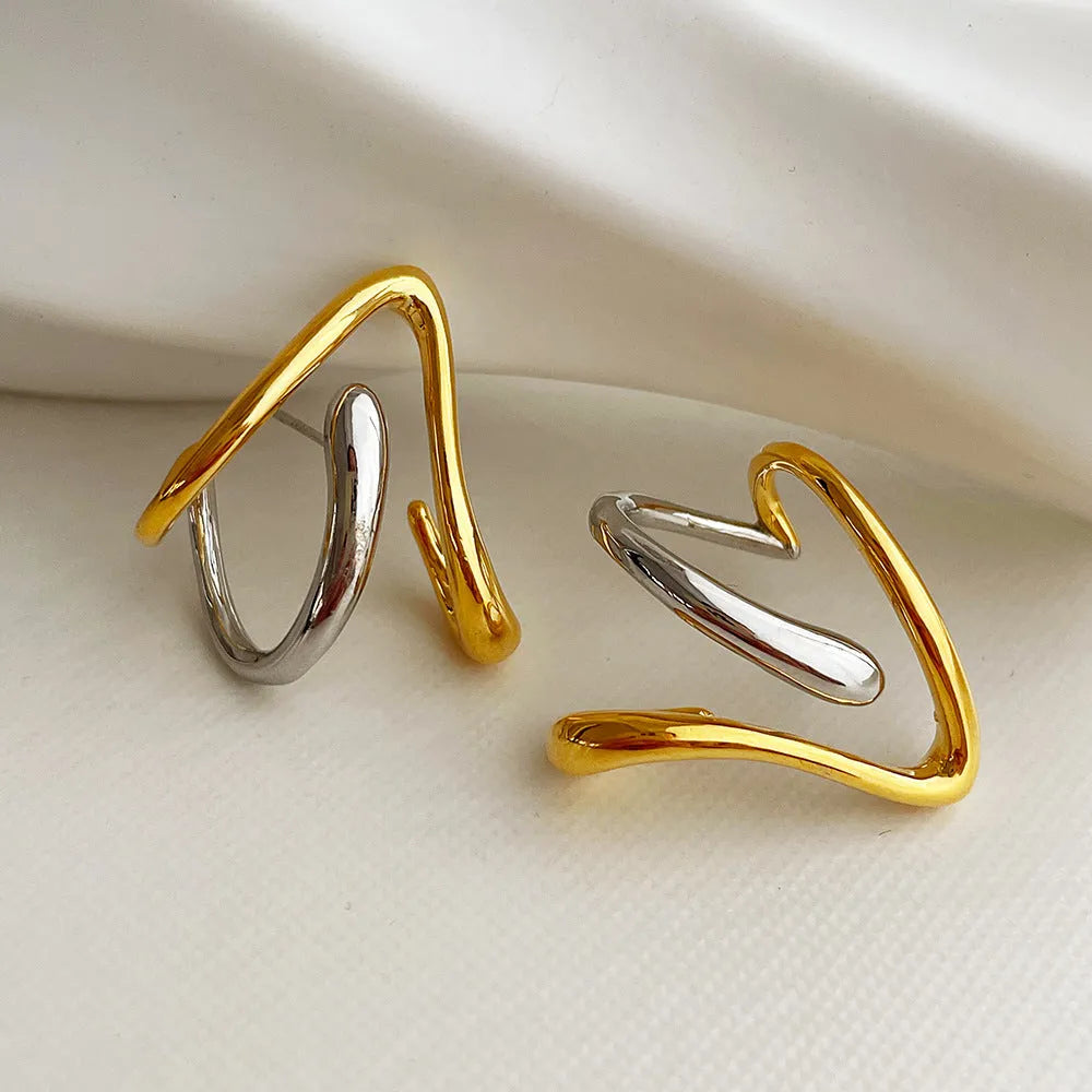Gold and silver irregular triangle alloy stud earrings with sterling silver needle on neutral background