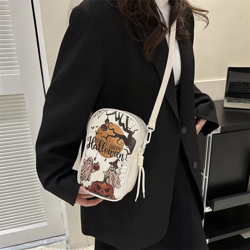 Halloween graffiti print crossbody phone bag with cartoon pumpkins, in multiple colours.