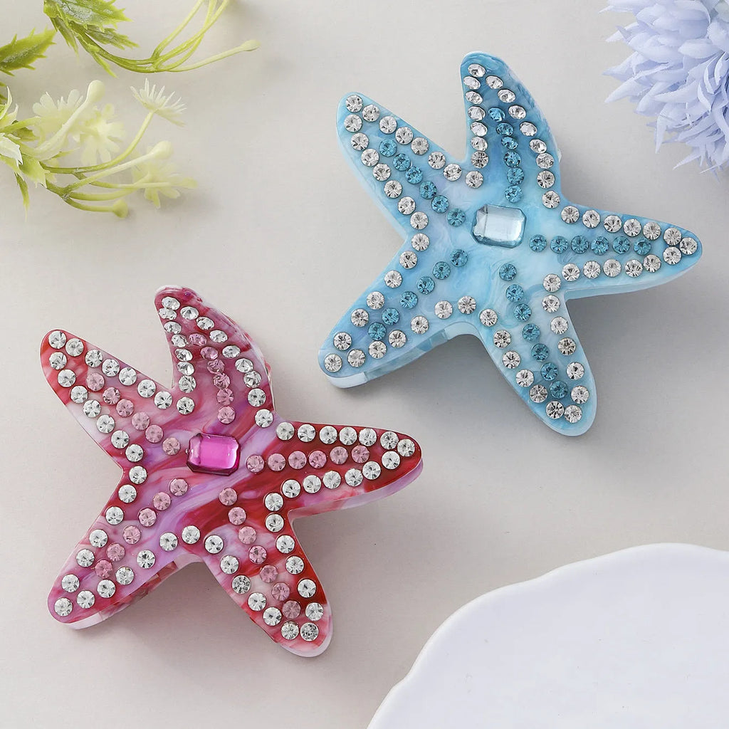 Blue acrylic starfish hairpin with diamond-encrusted surface on white background