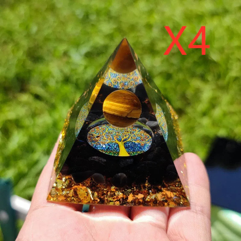 Clear epoxy resin pyramid ornament with natural crystal gravel inside on a wooden surface.