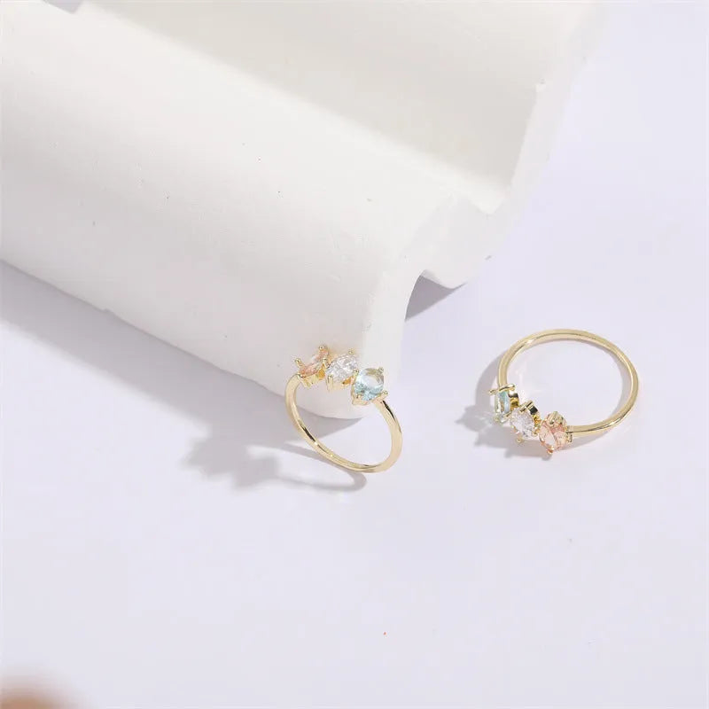 Geometric gold-colour women's ring with a triangular horse eye tricolour zircon stone.
