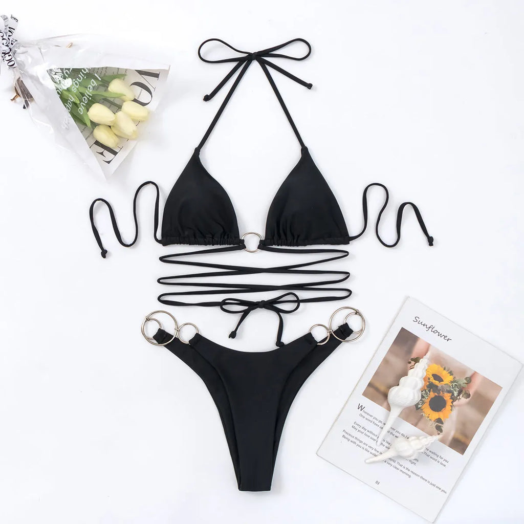 Black women's bikini set with metal ring straps and a backless, split cut design.