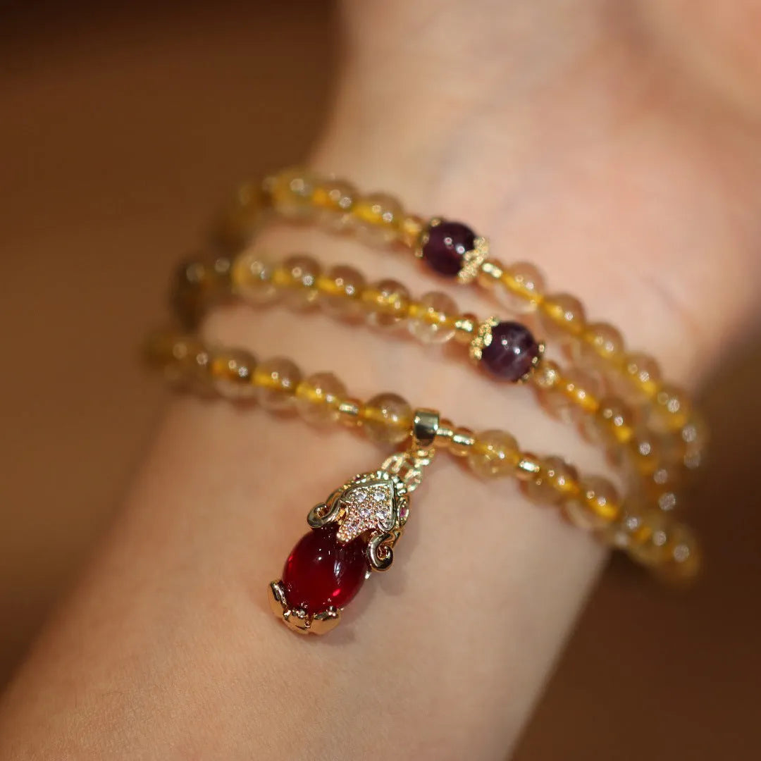Natural gold rutilated quartz bracelet with three-circle gold and ruby bead design