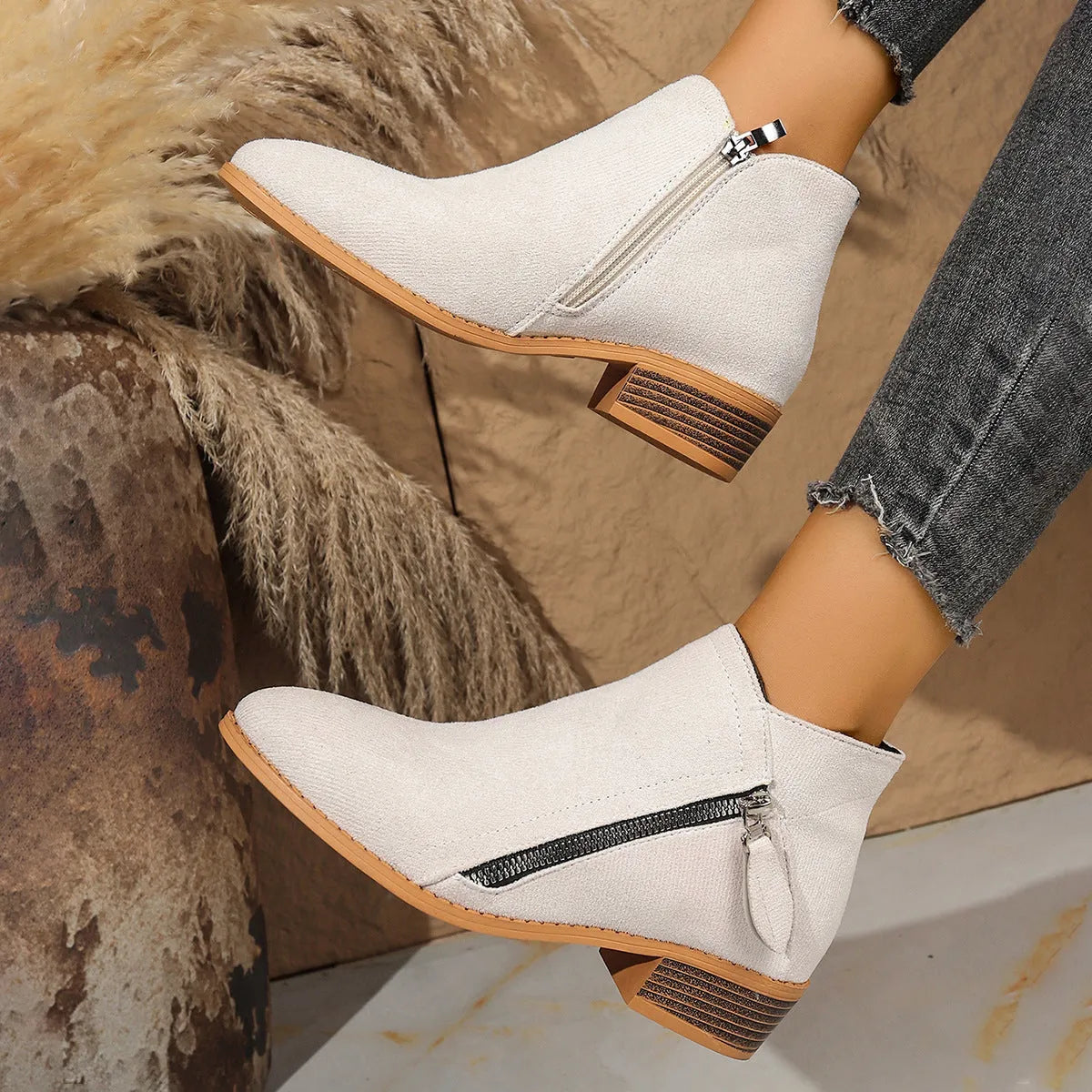 Suede women's ankle boots with side zipper in beige, shown on a white background
