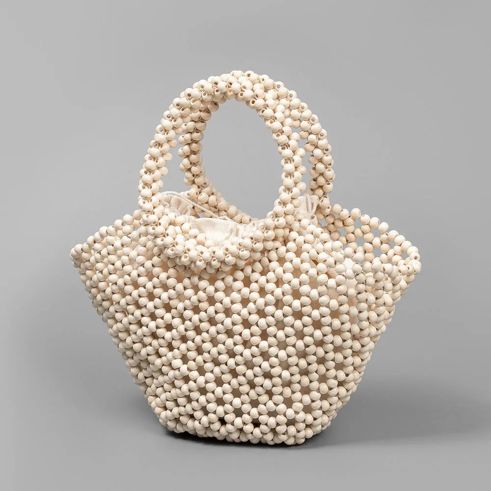 Hand-woven dumpling-shaped handbag with wooden beads in milky white colour