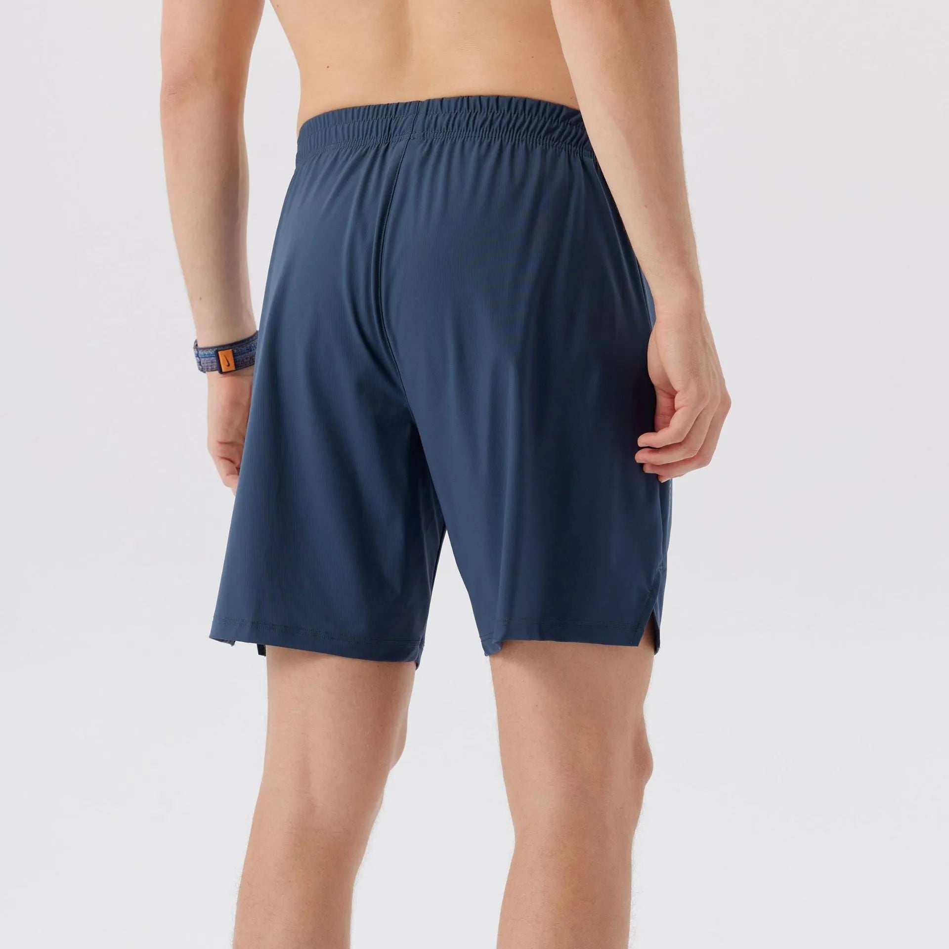 Man wearing grey ice silk nylon sports shorts with a mid-rise waistband.