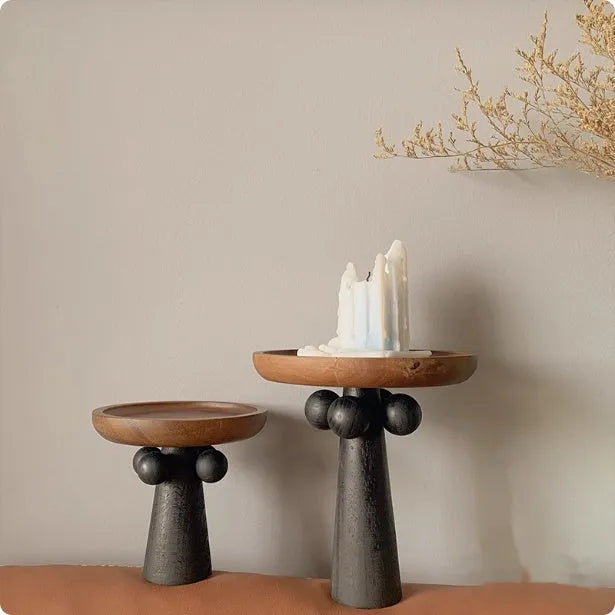 High-legged round wooden tray in a modern Nordic style for candle and decor display.