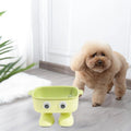 Green robot-shaped elevated cat bowl with tilted design and removable inner bowl on anti-slip base