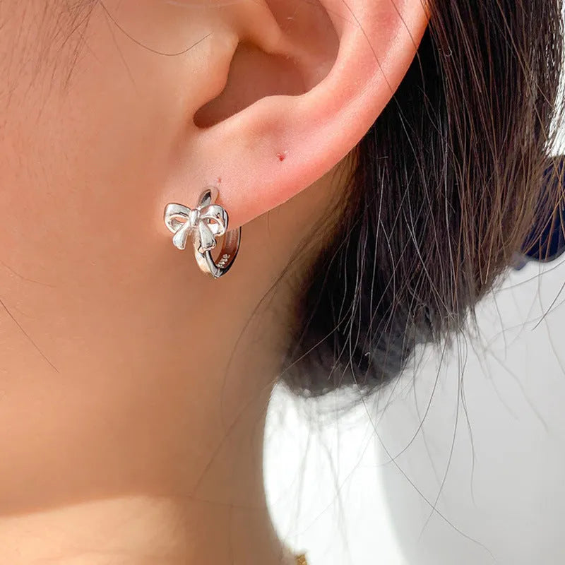 925 sterling silver bow earrings for women with silver electroplated finish on a white background