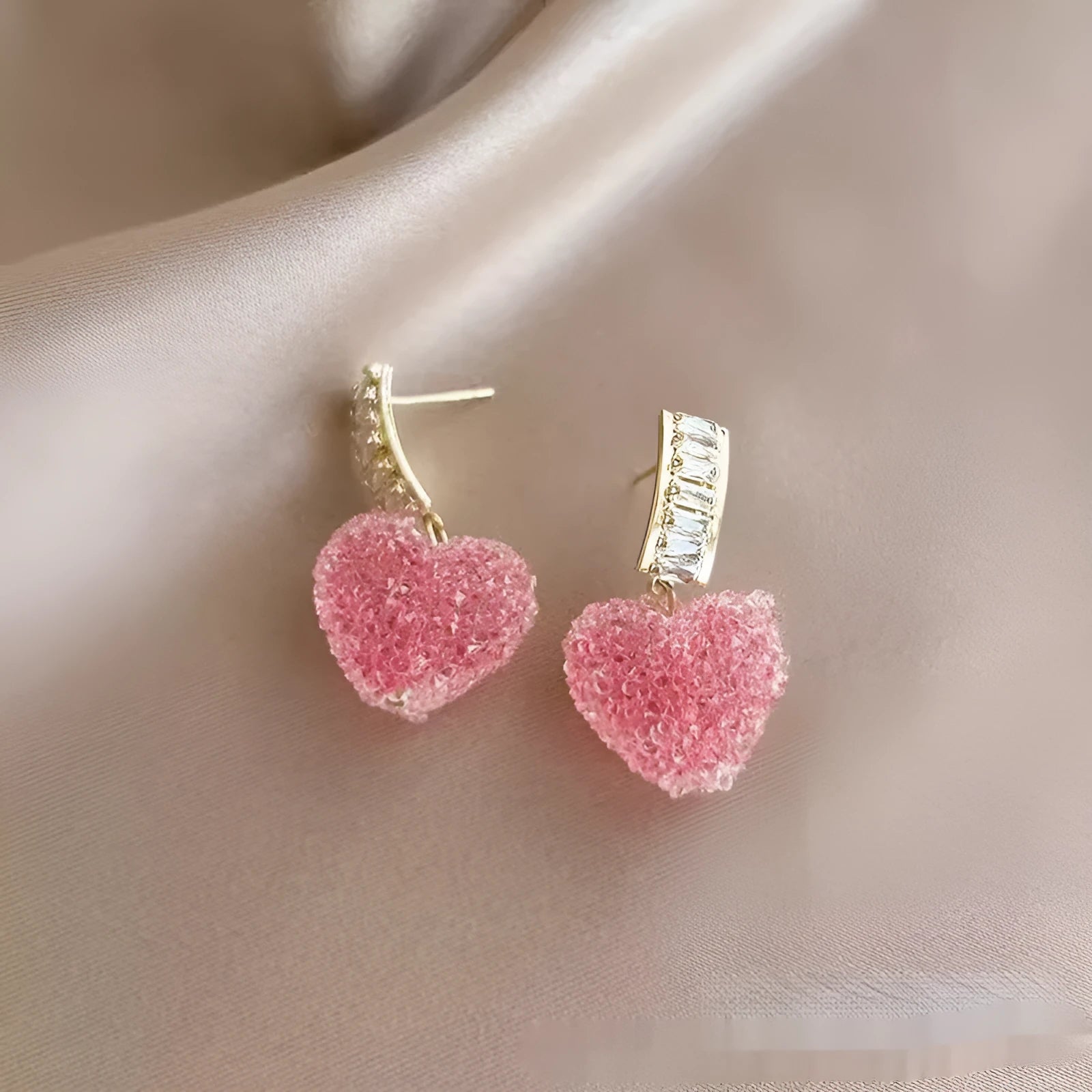 Close-up of women's cute alloy candy stud earrings with a peach heart design in pink and blue.