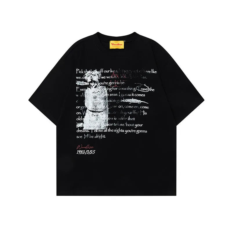 Man wearing a black loose-fit cotton T-shirt with a white printed letter pattern and raglan short sleeves.