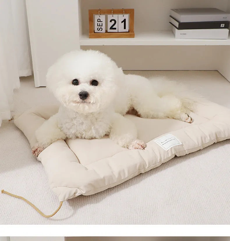 Beige pet cage cushion secured inside a metal dog crate, showing tie straps.
