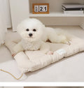 Beige pet cage cushion secured inside a metal dog crate, showing tie straps.