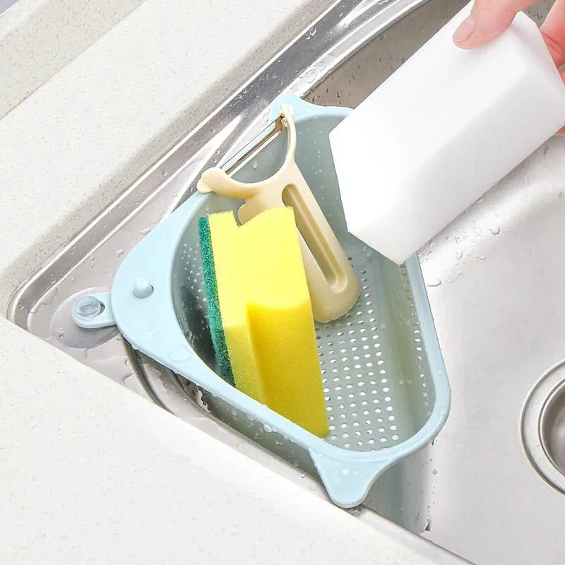 Beige plastic triangle sponge drain rack hanging from a kitchen faucet.