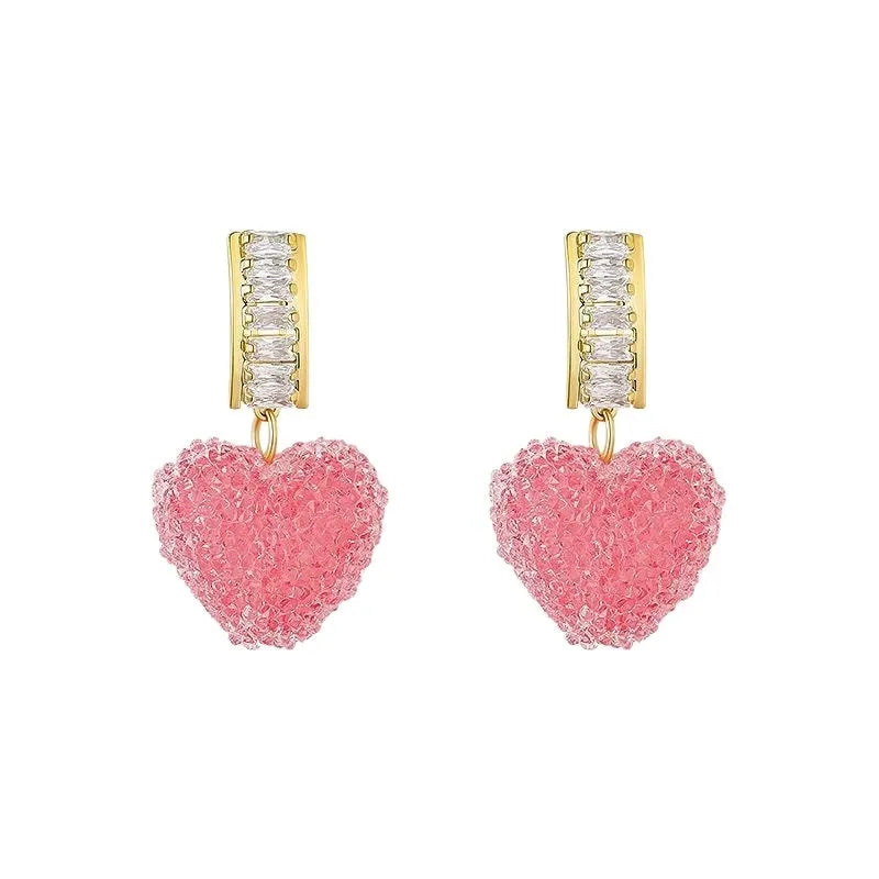 Close-up of women's cute alloy candy stud earrings with a peach heart design in pink and blue.