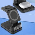 Black magnetic three-in-one wireless charger with clock and three charging pads on a desk