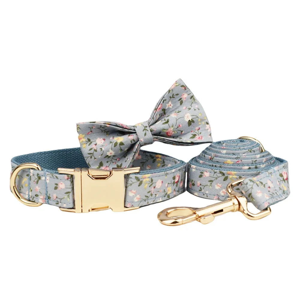 Blue floral patterned dog collar set with matching leash, bow, vest, and poop bag accessories