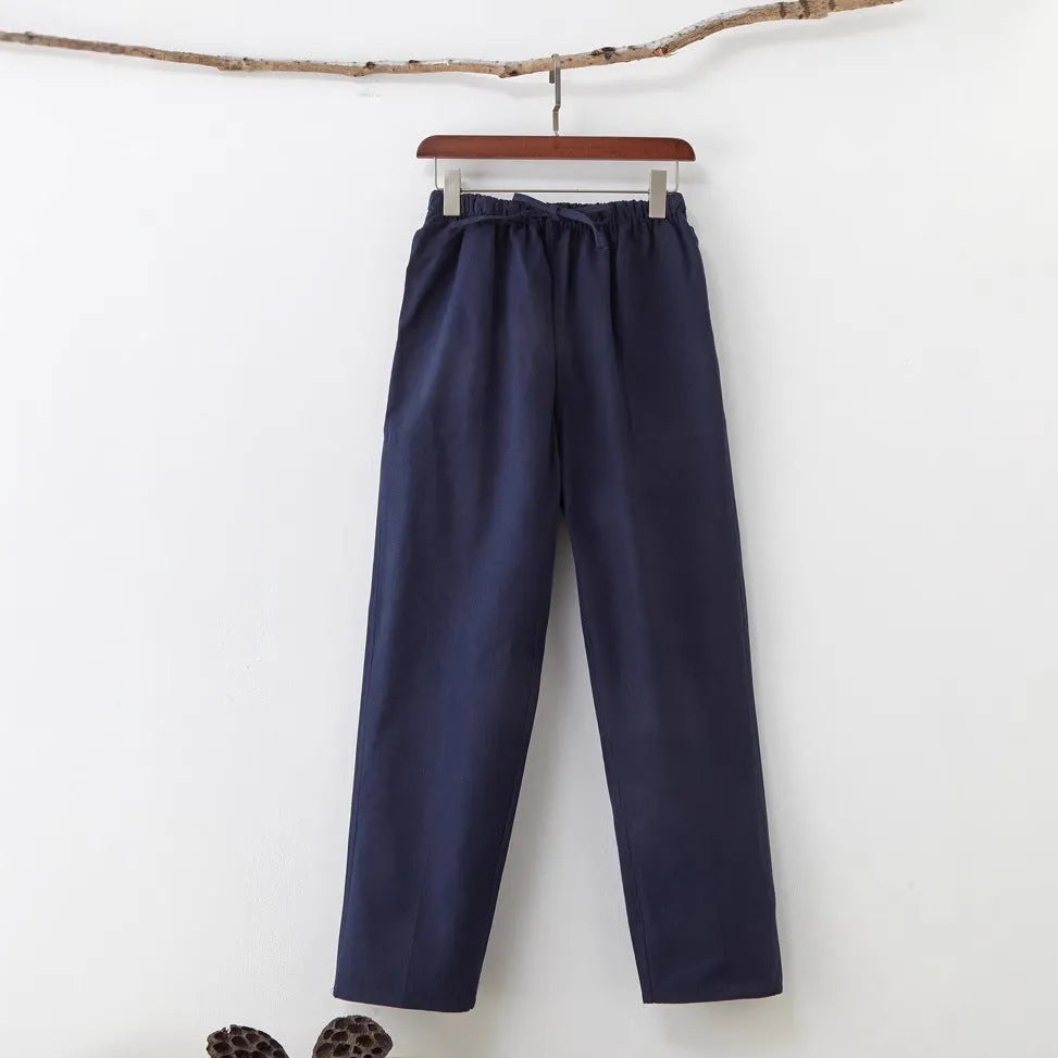 Man wearing beige pure cotton casual trousers with a drawstring waist and belt.
