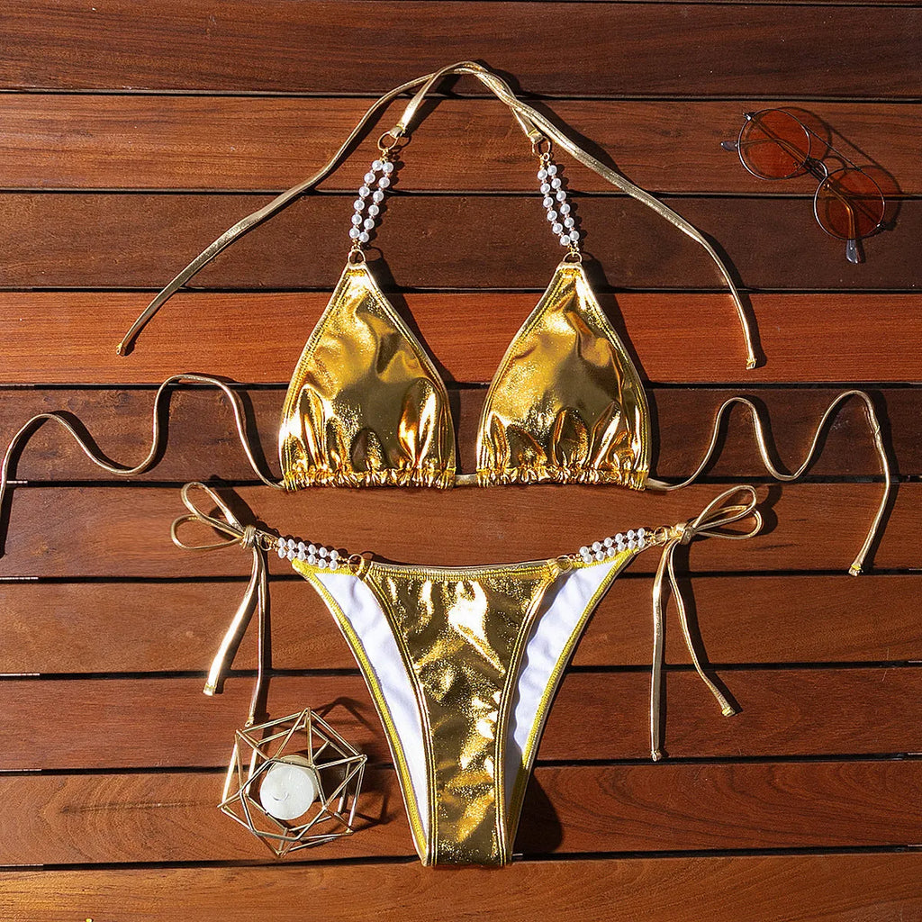 Gold halter lace-up bikini swimsuit with pearl chain detailing on mannequin