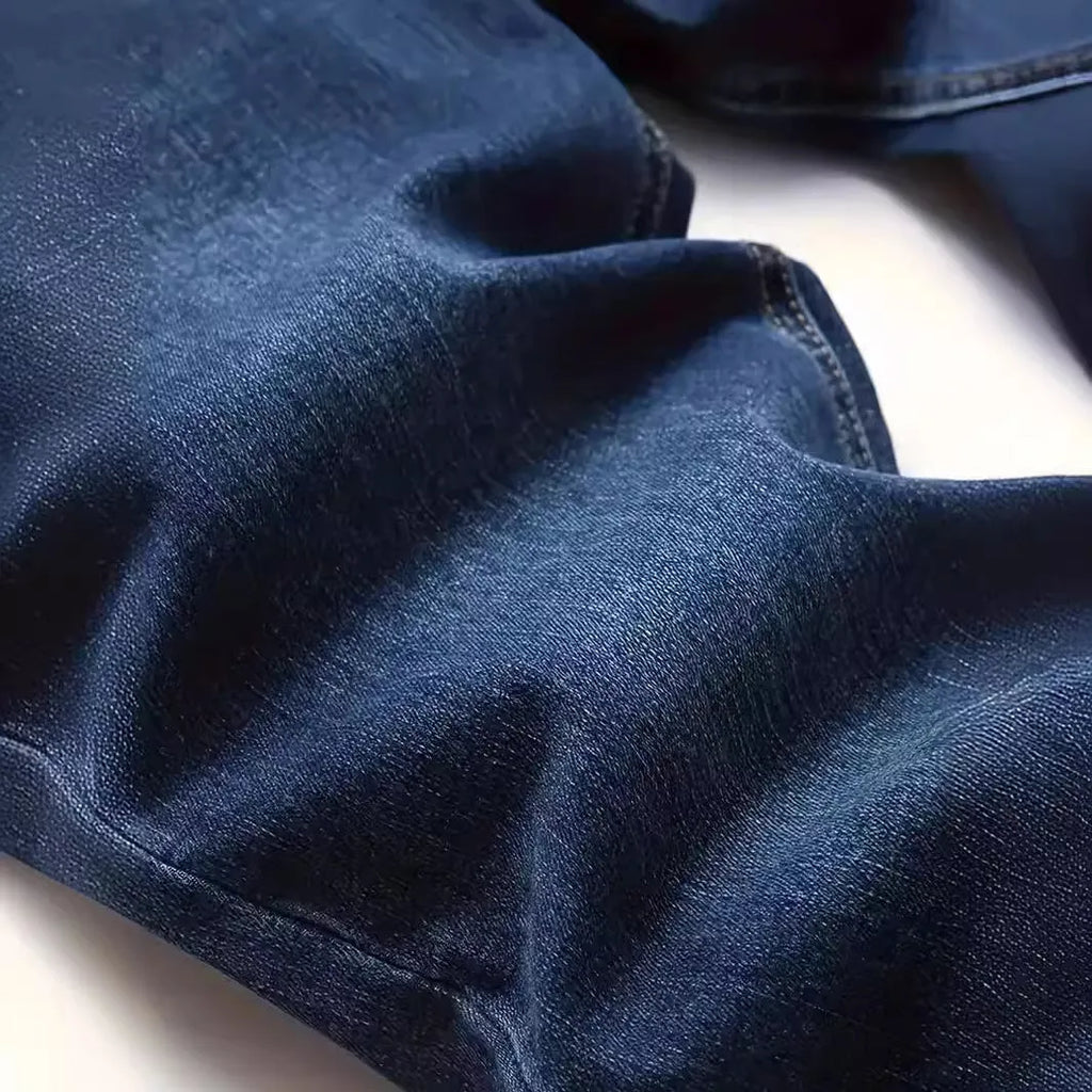 A man wearing dark blue slim fit casual jeans with an elastic waistband.