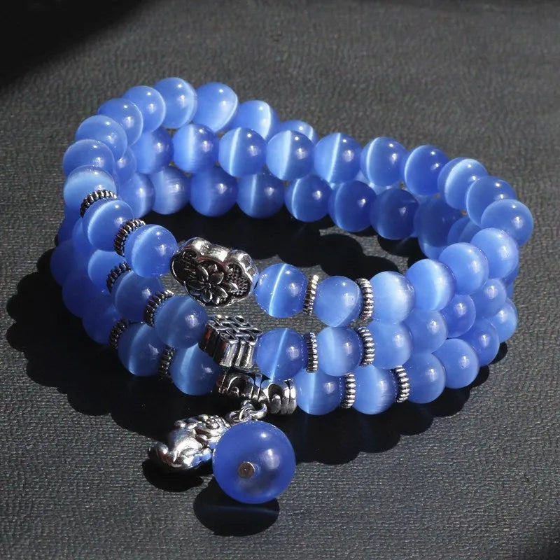 Opal crystal cat eye bracelet with lucky cat charm, shown in one of six colour options.
