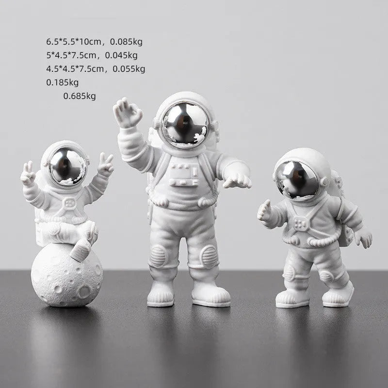 Three resin astronaut figurines for car dashboard decoration, gold finish, placed on dashboard