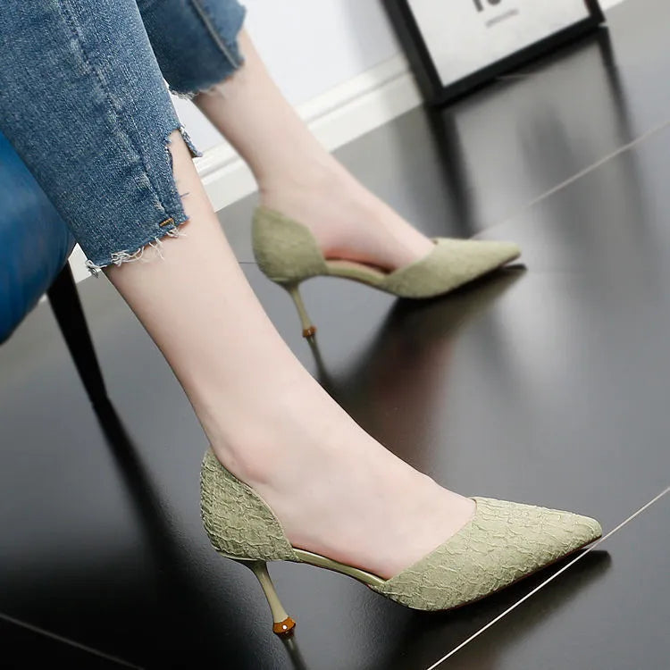 Women's black pointed high heel shoes with stiletto heel on light background