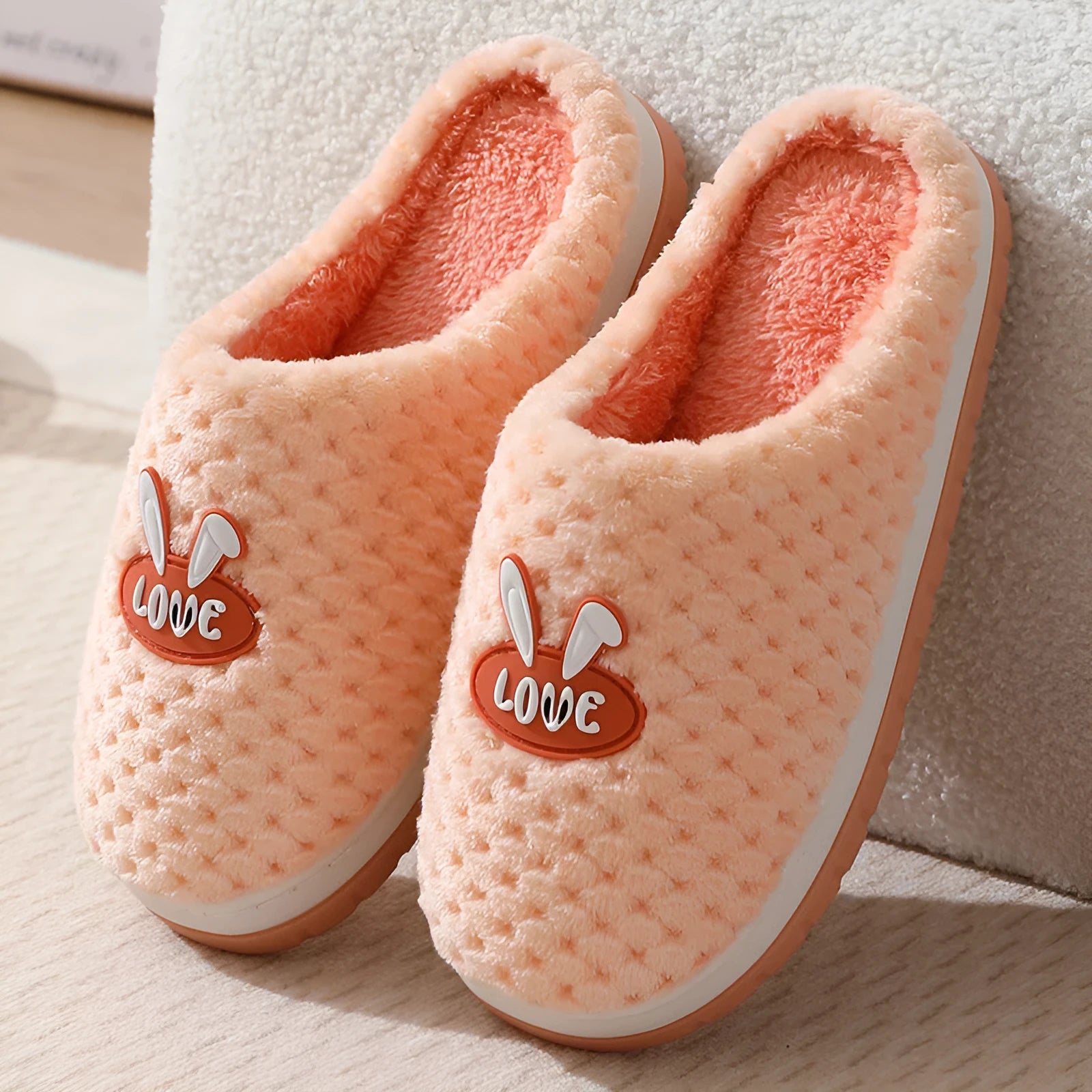 A pair of plush artificial fur house slippers with a baotou toe and a flat rubber sole, shown in a choice of colours.