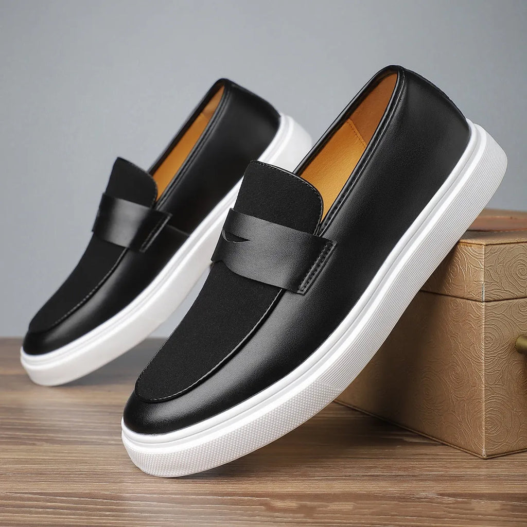 Men's black casual slip-on loafers with a tassel detail on the upper.