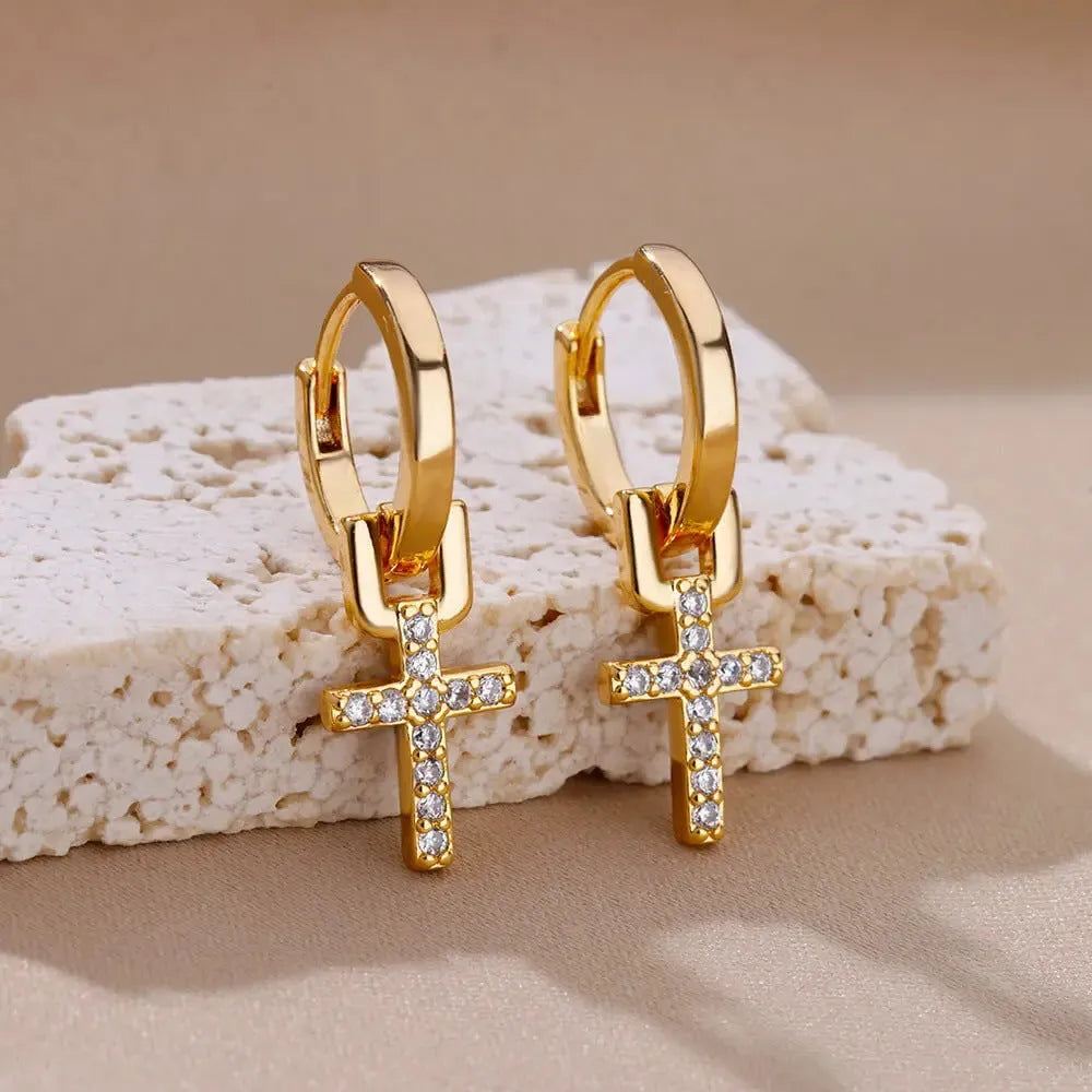 Cross stud earrings with 18K gold plating and clear zircon stone on a white background