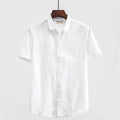 Men's light blue linen short sleeve shirt with a square collar on a hanger.