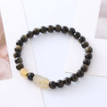 Handmade gold obsidian and red flower bead Pi Xiu bracelet on wrist, ethnic retro style.