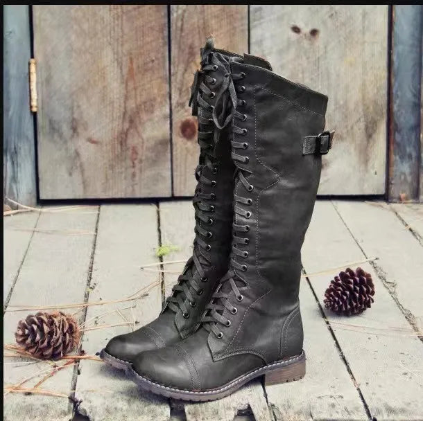 Black women's chunky heel high-leg boots with a round toe and short stout heel on a plain background.