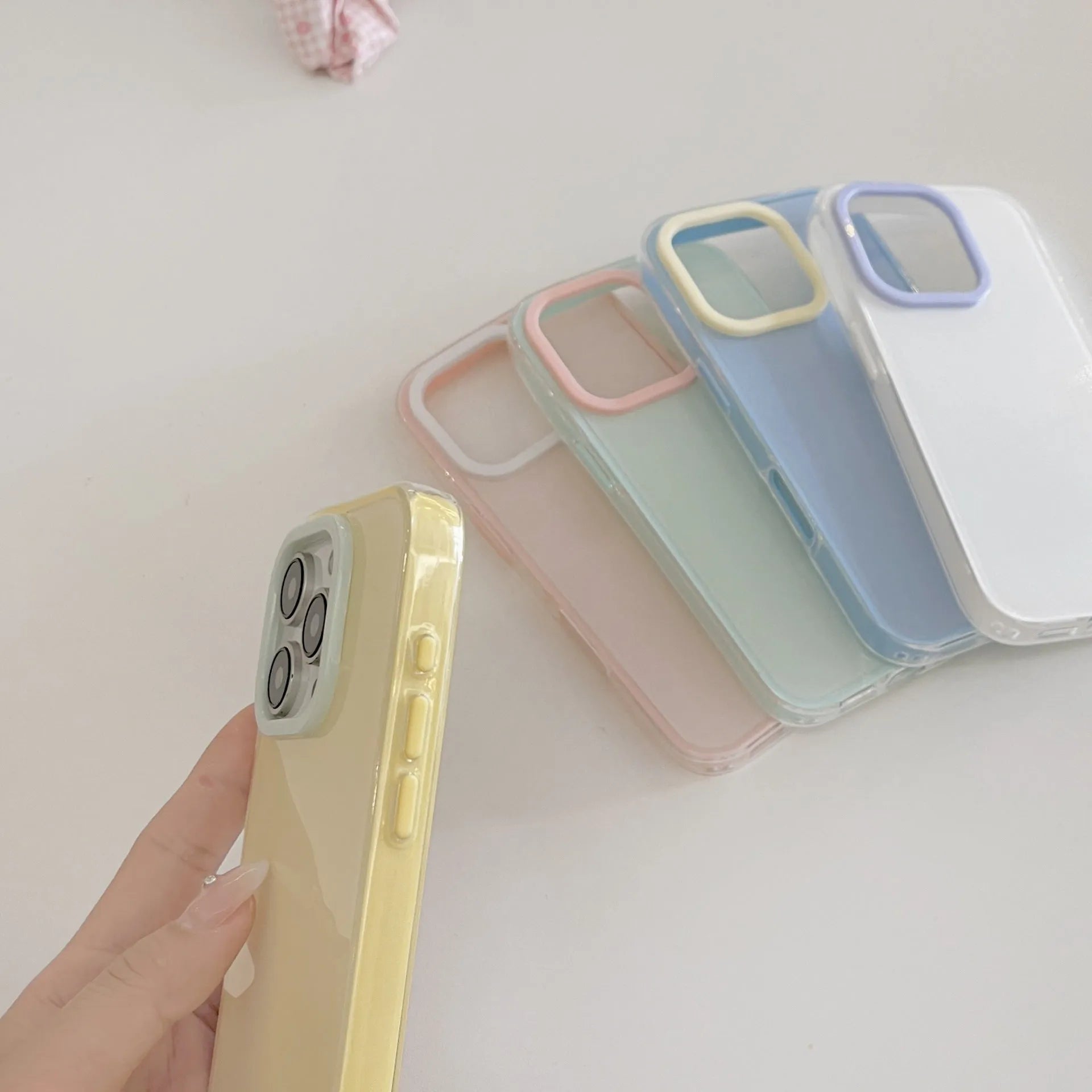 Simple solid colour jelly TPU phone case for iPhone, shown in blue, white, and yellow.